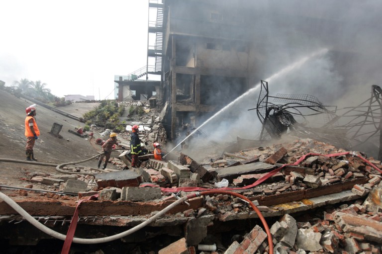 Bangladeshi firefighters try to extinguish a fire that break out from an explosion in a factory in the key Bangladeshi garment manufacturing town of Tongi just north of the capital Dhaka