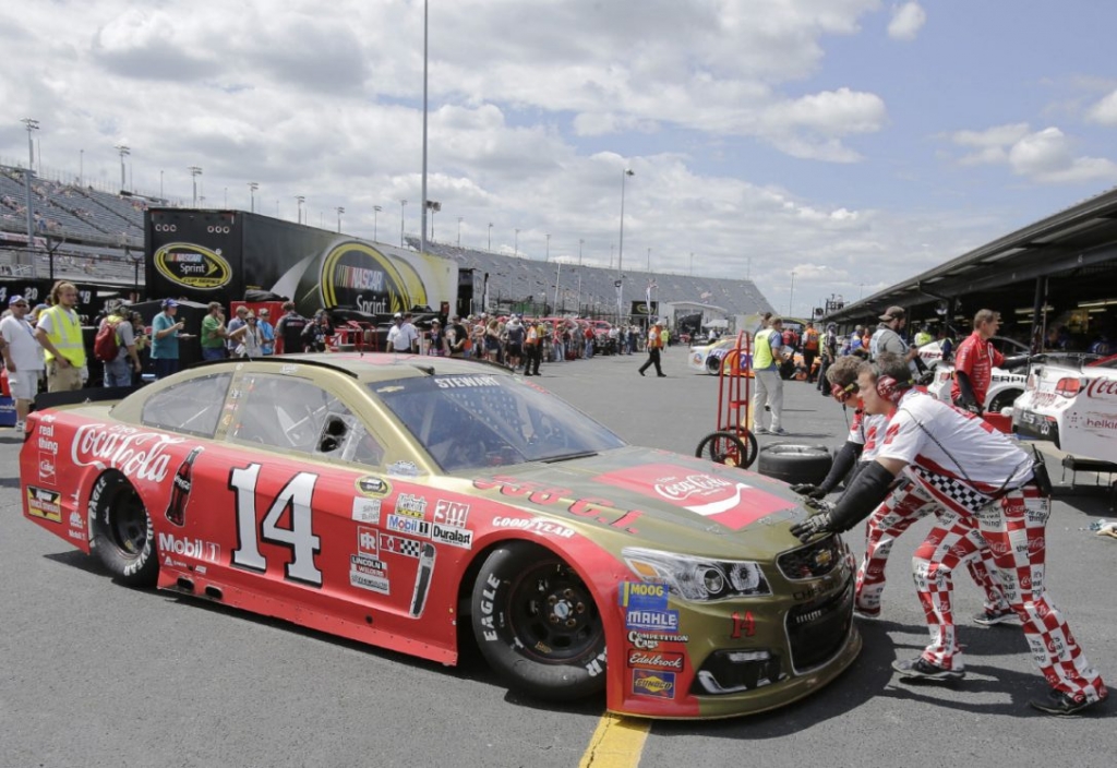 Tony Stewart backs out of the garage as his crew gives a push during NASCAR Sprint Cup auto racing practice at Darlington Raceway. The paint scheme and crew uniforms are part of throwback weekend at the track