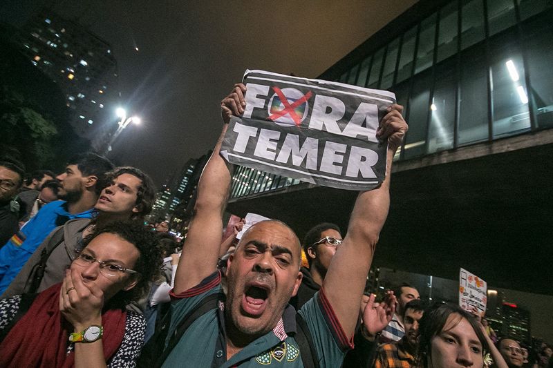 Thousands of people holding banners and shouting slogans do rally in favor of the former president of Brazil Dilma Rousseff on Paulista Avenue in Sao Paulo Brazil