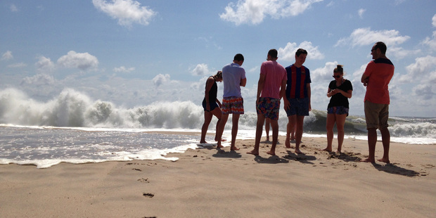 Beachgoers stand at the edge of the water in Bridgehampton New York on the southeastern shore of Long Island