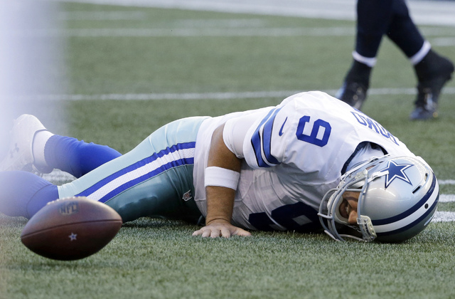 ASSOCIATED PRESS           Dallas Cowboys quarterback Tony Romo lies on the turf after he went down on a play against the Seattle Seahawks during the first half of a preseason NFL football game