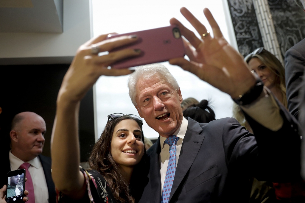 Former President Bill Clinton pauses for a selfie with a supporter at a coffee shop while campaigning for his wife Democratic presidential candidate Hillary Clinton Tuesday Sept. 13 2016 in Los Angeles