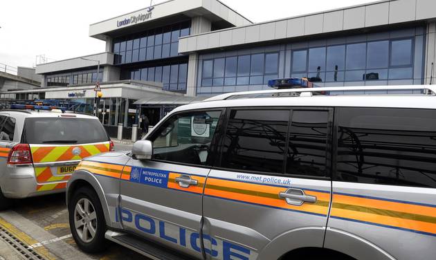 Police cars parked outside London City Airport Tuesday Sept. 6 2016. All flights in and out of London City Airport were disrupted on Tuesday after demonstrators blocked a runway to protest expansion