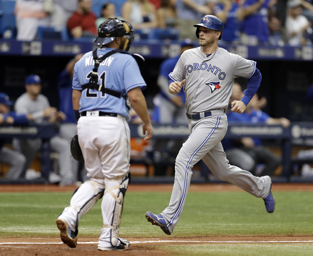 Toronto Blue Jays Michael Saunders right scores in front of Tampa Bay Rays catcher Bobby Wilson on a
two-run single by Devon Travis during the seventh