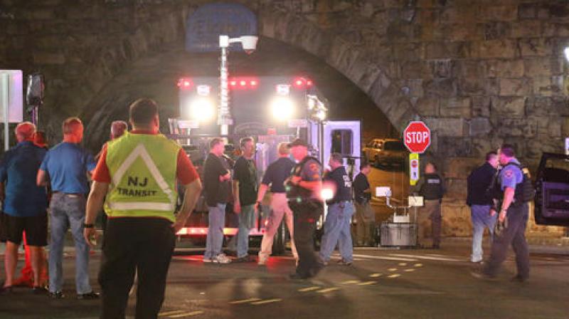 Bomb squad personnel stand around the scene of an explosion near the train station in Elizabeth,New Jersey