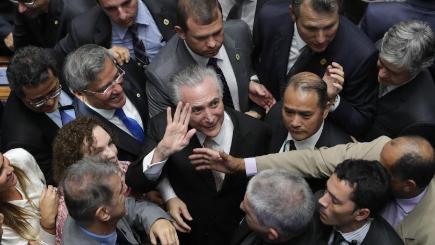 Michel Temer is surrounded by senators as he arrives to take the presidential oath at the National Congress in Brasilia