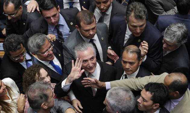 Brazil's President Michel Temer center is surrounded by senators as he arrives to take the presidential oath at the National Congress in Brasilia Brazil Wednesday Aug. 31 2016. Temer was sworn in as Brazil's new leader following the ouste