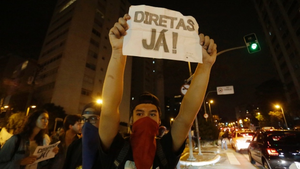 A man holds a sign that reads 'Elections now&#39 during a protest against President Michel Temer in Sao Paulo Brazil on Sunday