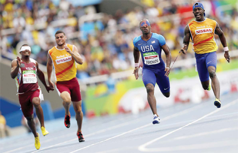 RIO DE JANEIRO David Brown of the United States second from right accompanied by his guide Jerome Avery and Venezuela’s Fernando Ferrer left accompanied by his guide Edison Medina compete in the men’s 100-meter T11 round 1 heat 5 during the