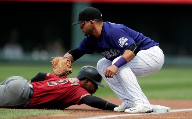 Colorado Rockies first baseman Gerardo Parra front fields the pickoff throw as Arizona Diamondbacks&#39 Jean Segura dives back into first base in the first inning of a baseball game Sunday Sept. 4 2016 in Denver