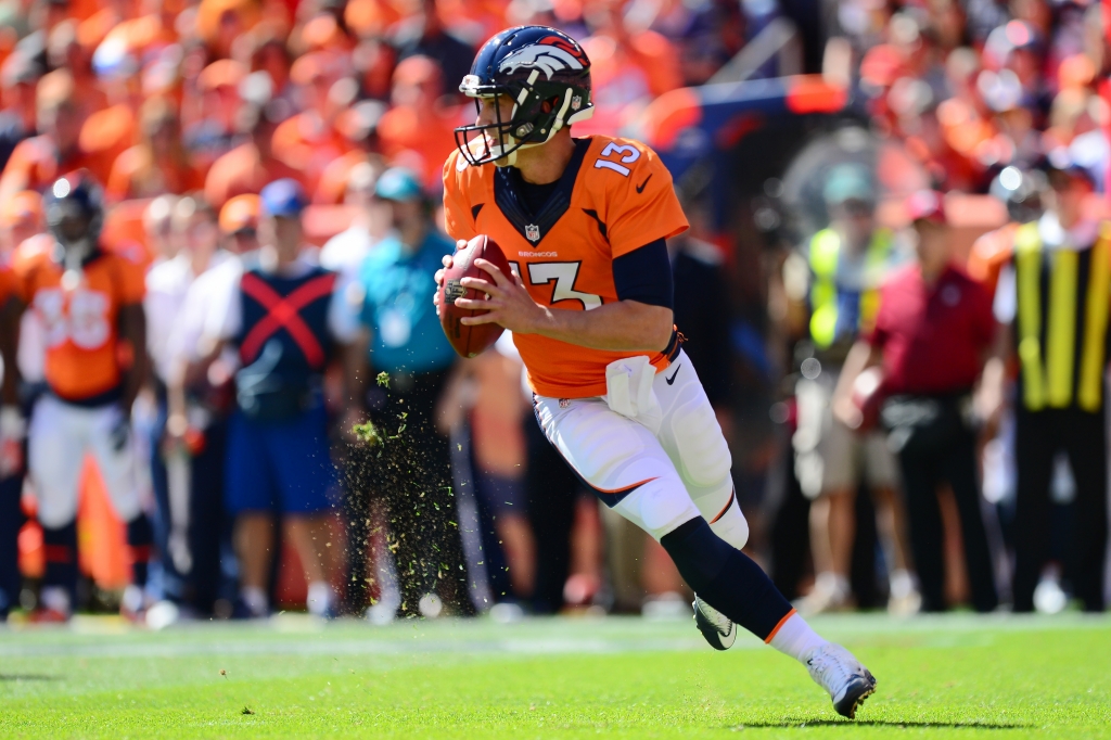 DENVER CO- SEPTEMBER 18 Quarterback Trevor Siemian #13 of the Denver Broncos rolls out and throws a completion in the first quarter of the game against the Indianapolis Colts at Sports Authority Field at Mile High