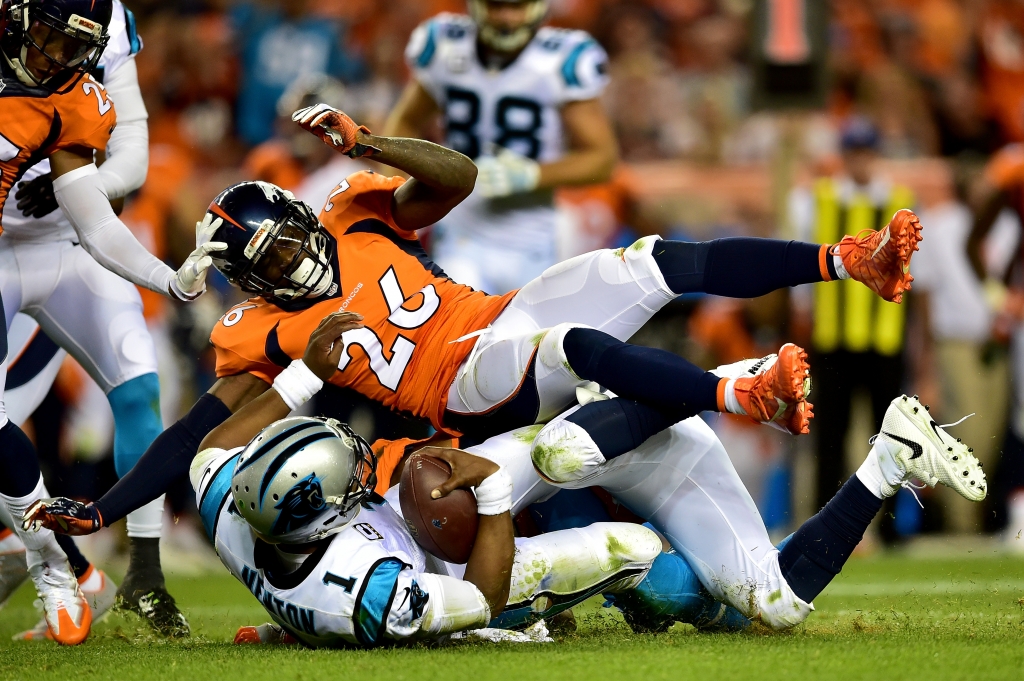 Quarterback Cam Newton #1 of the Carolina Panthers is hit by free safety Darian Stewart #26 of the Denver Broncos in the third quarter at Sports Authority Field at Mile High