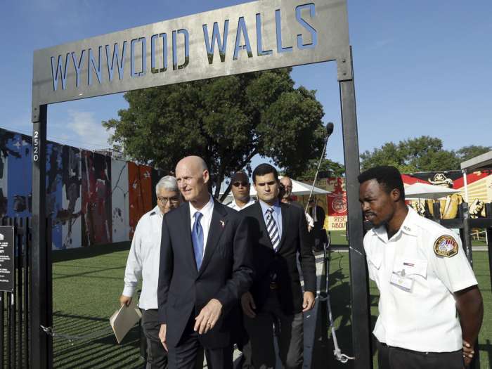 Florida Gov. Rick Scott center walks from Wynwood Walls after a news conference Monday Sept. 19 2016 in the Wynwood neighborhood of Miami. The governor said the arts district is no longer considered a zone of active Zika transmission. It has been 45