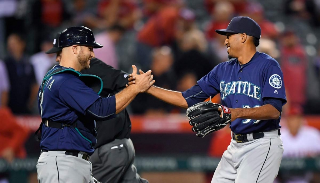 Seattle Mariners catcher Chris Iannetta left and relief pitcher Edwin Diaz congratulate each other after the Mariners defeated the Los Angeles Angels 2-1 in a baseball game Wednesday Sept. 14 2016 in Anaheim Calif