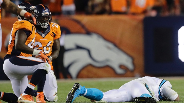 Carolina Panthers quarterback Cam Newton right lies on the turf after taking a hit against the Denver Broncos on Thursday. On Friday the NFL released a statement saying that Newton did not need to leave the game after taking a helmet-to-helmet shot