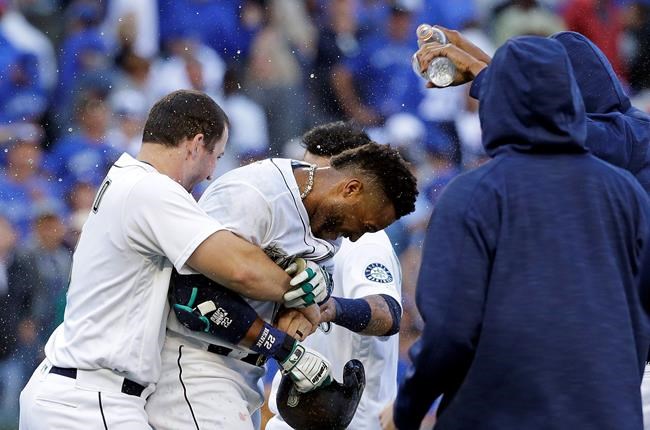 Seattle Mariners&#39 Mike Zunino left holds Robinson Cano as other players douse Cano with water after his game-winning sacrifice fly against the Toronto Blue Jays in a baseball game Wednesday Sept. 21 2016 in Seattle. The Mariners won 2-1 in 12 inn