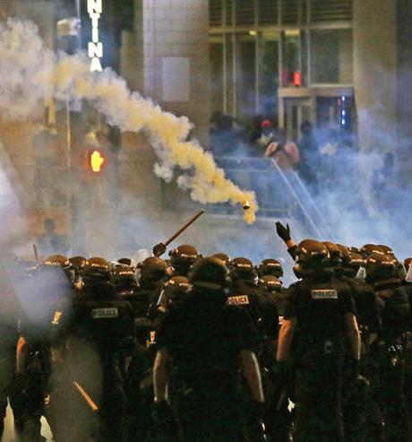 Police fire tear gas as protestors converge downtown following Tuesday's police shooting of Keith Lamont Scott in Charlotte N.C. Wednesday Sept. 21 2016. Protesters have rushed police in riot gear at a downtown Charlotte hotel and officers have