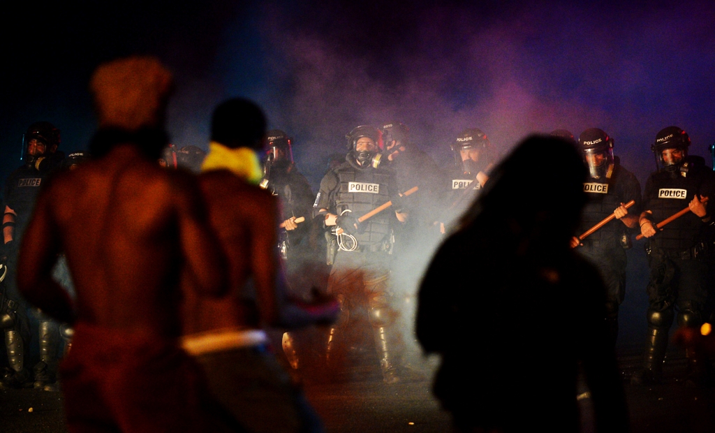 Officers stand in formation in front of protesters in Charlotte N.C. on Tuesday Sept. 20 2016. Authorities used tear gas to disperse protesters in an overnight demonstration that broke out Tuesday after Keith Lamont Scott was fatally shot by an officer