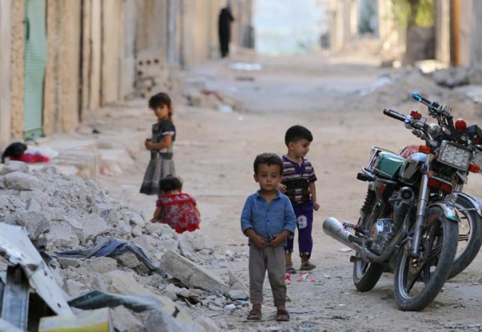 Children play along a street in the rebel-held al Sheikh Said neighbourhood of Aleppo Syria