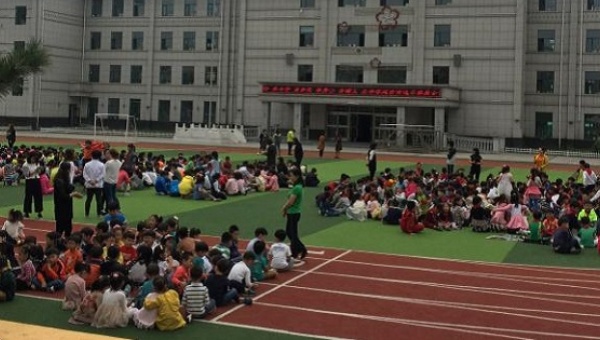 Students sit on a playground of a school in Yanji Jilin Province China as they are evacuated after a seismic event in North Korea