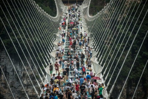 Visitors cross the world's highest and longest glass-bottomed bridge above a valley in Zhangjiajie China's Hunan province