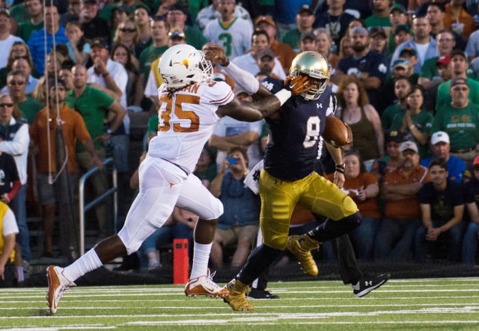 Irish senior Malik Zaire stiff arms a defender during Notre Dame’s 38-3 victory over Texas on Sept. 5 at Notre Dame Stadium