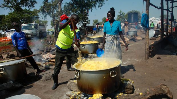 Refugees make maize porridge at a transit centre for South Sudanese refugees in the remote north-western district