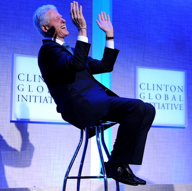 Former US President Bill Clinton laughs during remarks by President Barack Obama at the Clinton Global Initiative