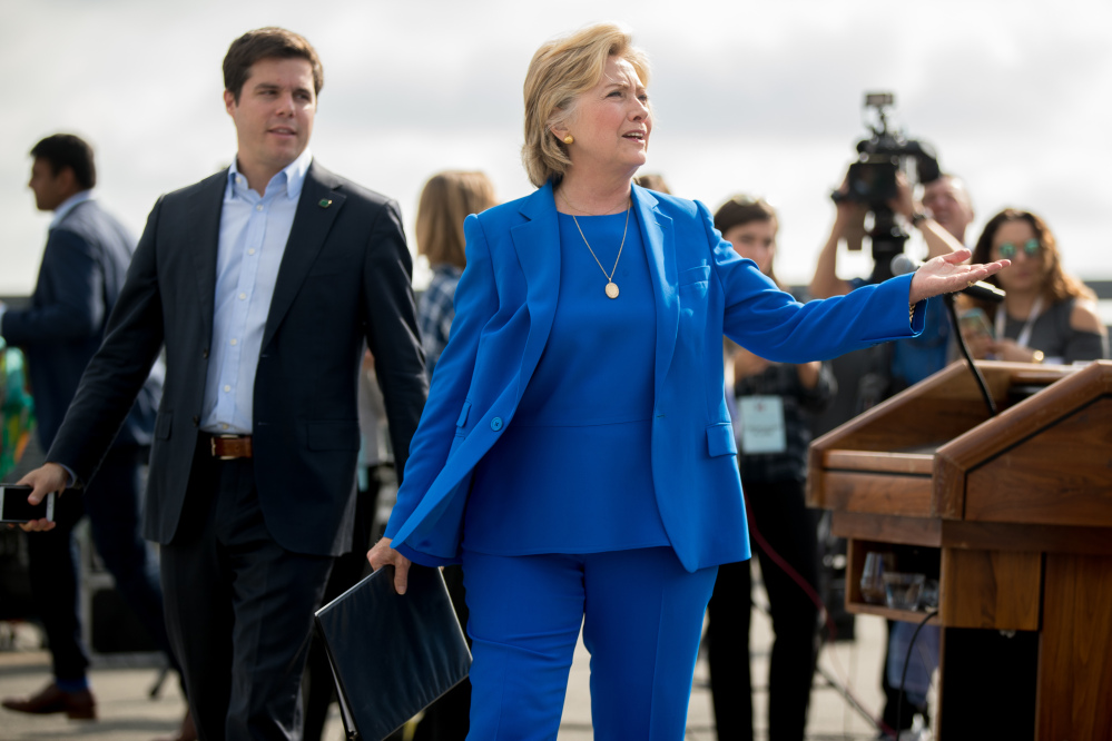 Democratic presidential nominee Hillary Clinton accompanied by traveling press secretary Nick Merrill left reacts to a reporter's question as she finishes speaking to members of the media before boarding her campaign plane at Westchester County Airport