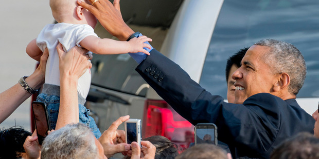 While greeting well-wishers after arriving at John F. Kennedy International Airport in New York President Barack Obama reaches out to Desmond Hatfield-Rudin 8 months old