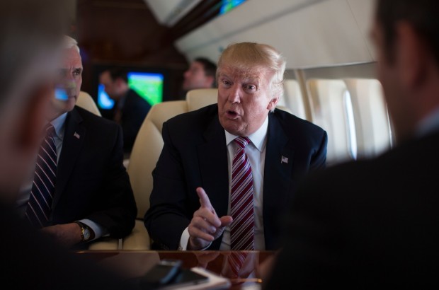 Republican presidential candidate Donald Trump talks with press Monday Sept. 5 2016 aboard his campaign plane while flying over Ohio as Vice presidential candidate Gov. Mike Pence R-Ind. left looks