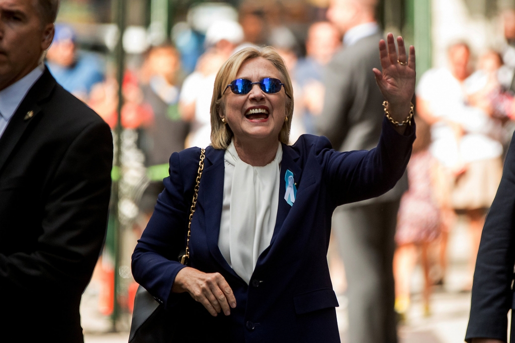 Democratic presidential candidate Hillary Clinton waves after leaving an apartment building Sunday Sept. 11 2016 in New York. Clinton's campaign said the Democratic presidential nominee left the 9/11 anniversary ceremony in New York early after