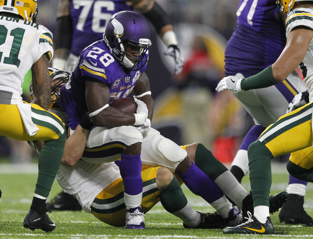 ASSOCIATED PRESS           Minnesota Vikings running back Adrian Peterson was tackled by Green Bay Packers outside linebacker Kyler Fackrell rear during the second half Sunday in Minneapolis. Peterson was injured on the play and