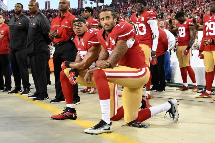 Colin Kaepernick and teammate Eric Reid kneel as the national anthem is played before Monday night's 49ers Rams game in San Francisco