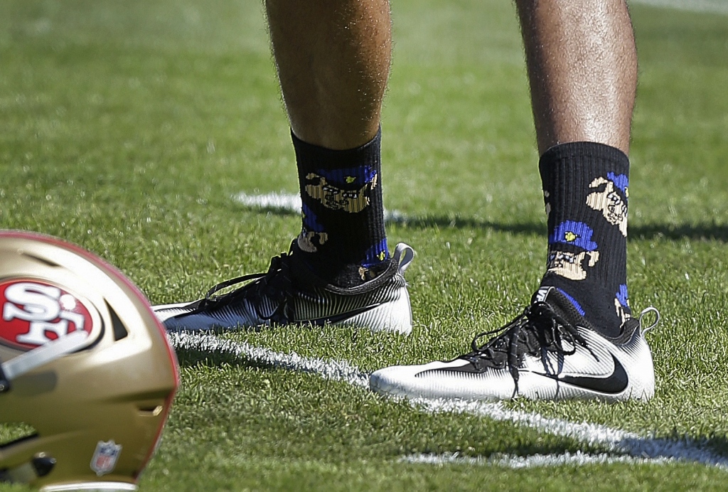 San Francisco 49ers quarterback Colin Kaepernick wears socks depicting police officers as pigs during NFL football training camp at Kezar Stadium in San Francisco. Kaepernick says he has been wearing socks depicti