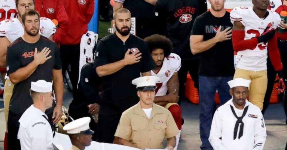 Colin Kaepernick R and his teammate Eric Reid L kneel during Thursday night's game against the San Diego Chargers