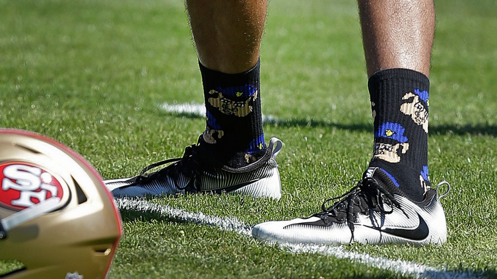 San Francisco 49ers quarterback Colin Kaepernick wears socks depicting police officers as pigs during NFL football training camp at Kezar Stadium in San Francisco