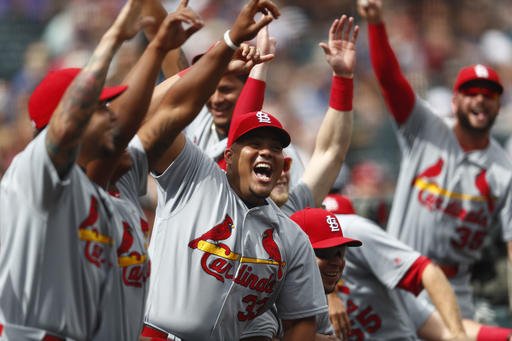 St. Louis Cardinals catcher Brayan Pena center celebrates with teammates after right fielder Jose Martinez won a stand off against Colorado Rockies relief pitcher Carlos Estevez after the teams dispersed following the playing of the National Anthem befo