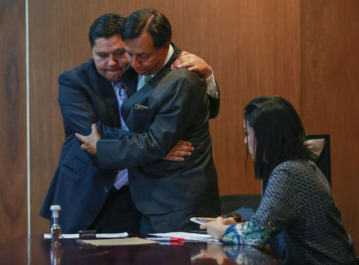 FARC victim Harry Gonzales left hugs Hector Riveros the leader of the “Obvio SI” Movement as it registers with the National Electoral Committee in Bogota on Thursday. — AFP