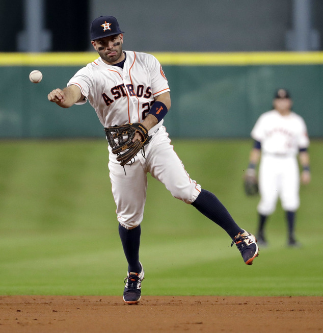 Houston Astros second baseman Jose Altuve throws to first for the out after fielding a grounder by Texas Rangers Robinson Chirinos during the third inning