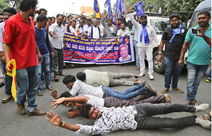 Activists lie on the ground as they shout slogans to protest against a recent Supreme Court order on a river water sharing dispute in Bangalore in the southern Indian state of Karnataka on Friday. — AP