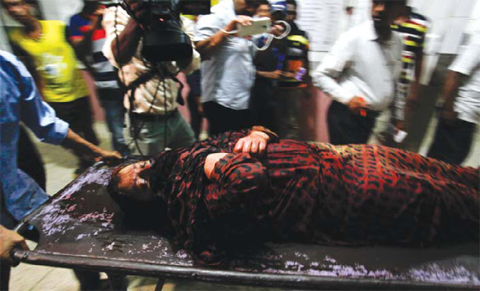 DHAKA Police and medical staff carry a suspected wounded militant on a stretcher for treatment at a hospital. — AFP