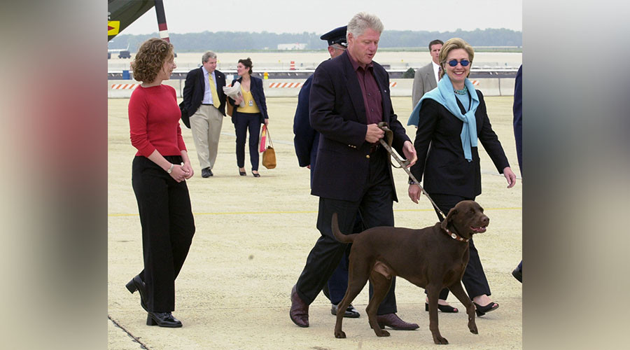 Clinton holds onto his dog Buddy as he walks with First Lady Hillary Rodham Clinton and daughter Chelsea as they board Air Force One at Andrew's Air Force Base to begin a weekend summer vacation at Martha&#0