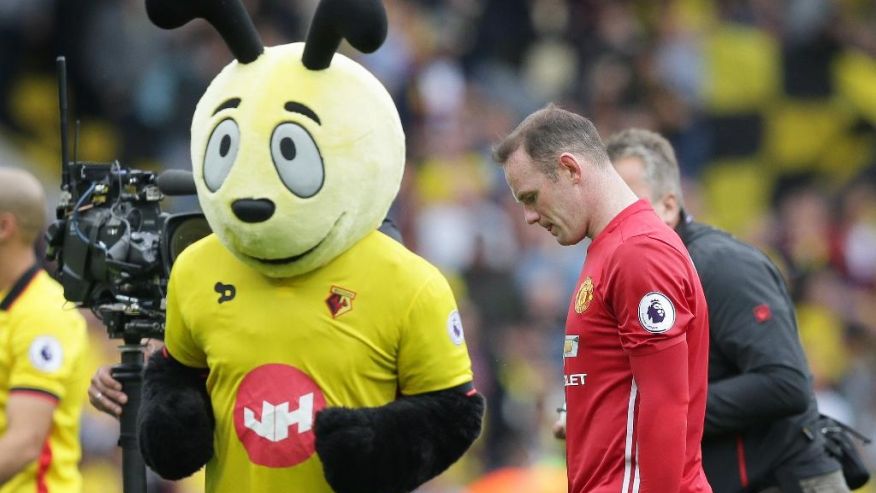 Manchester United's Wayne Rooney walks from the pitch past the Watford team mascot 'Harry the Hornet&#x27 after losing the English Premier League soccer match between Watford and Manchester United at Vicarage Road in London Sunday Sept. 18 20