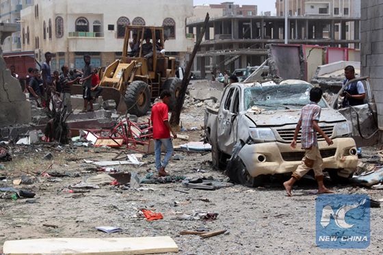 Yemenis inspect the site of a suicide car bombing claimed by the Islamic State group