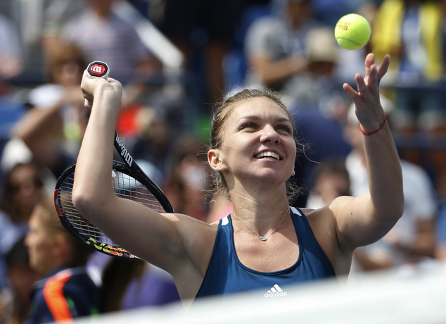 Simona Halep of Romania hits souvenir balls to fans after defeating Carla Suarez Navarro of Spain during the fourth round of the U.S. Open tennis tournam