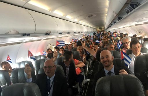 JetBlue flight 387 passengers hold up representations of Cuba's national flag just before touching down at the airport in Santa Clara Cuba Wednesday Aug. 31 2016. Jet Blue 387 the first commercial flight between the U.S. and Cuba in more than a half