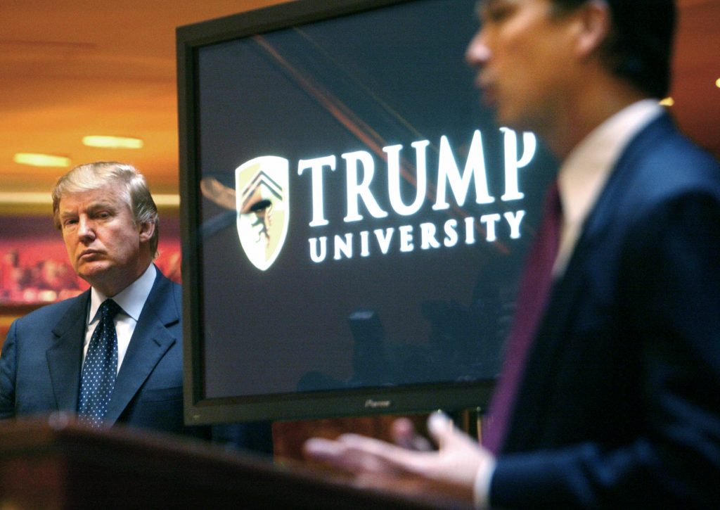 Donald Trump listens as Michael Sexton introduces him at a news conference in New York where he announced the establishment of Trump University in 2005