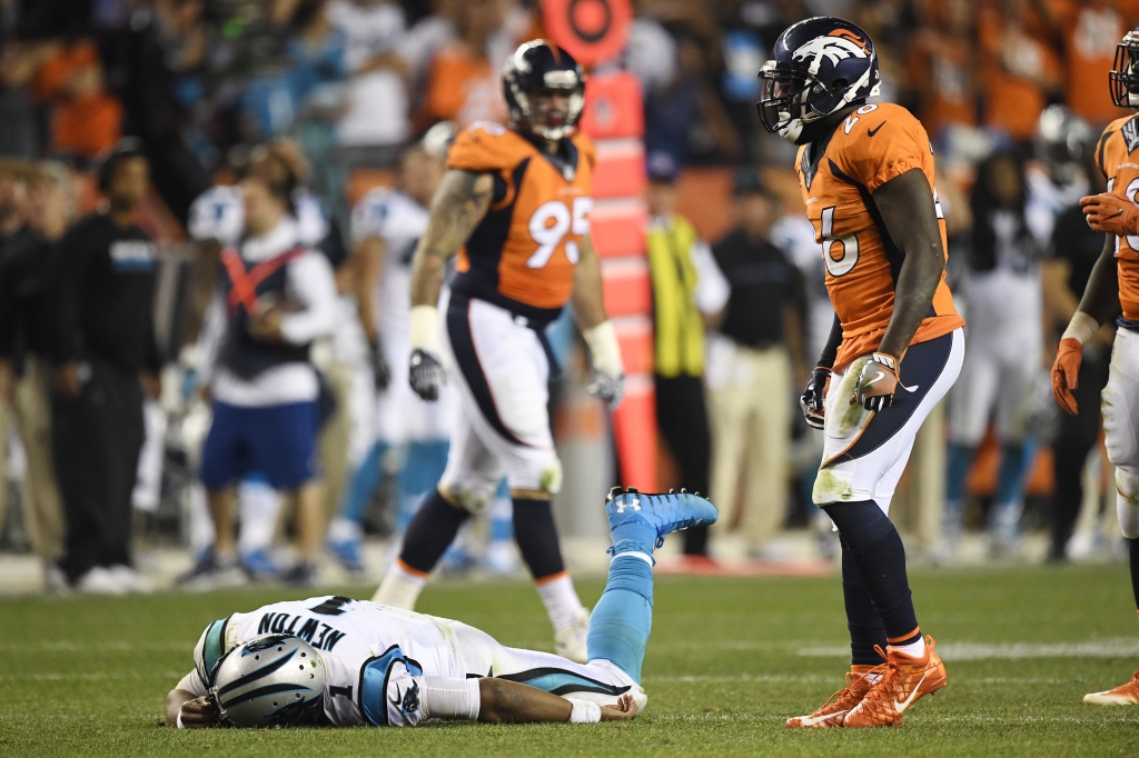 Cam Newton of the Carolina Panthers lies on the turf after getting hit hard by Darian Stewart of the Denver Broncos and Shaquil Barrett during the fourth quarter of the Broncos 21-20 win. The Denver Broncos hosted the Carolina Panthers on T