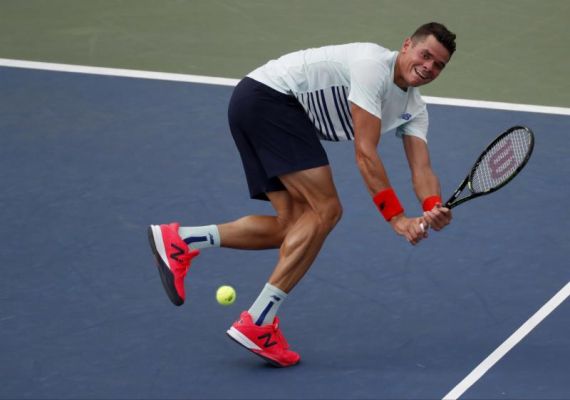 Milos Raonic of Canada returns a shot